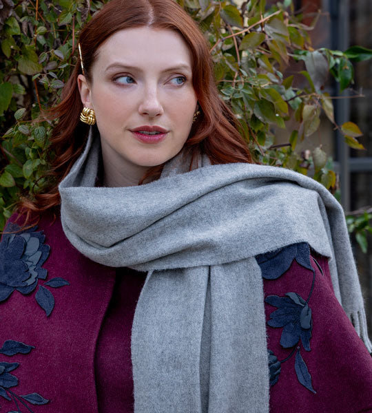 Woman wearing a grey cashmere scarf outside 