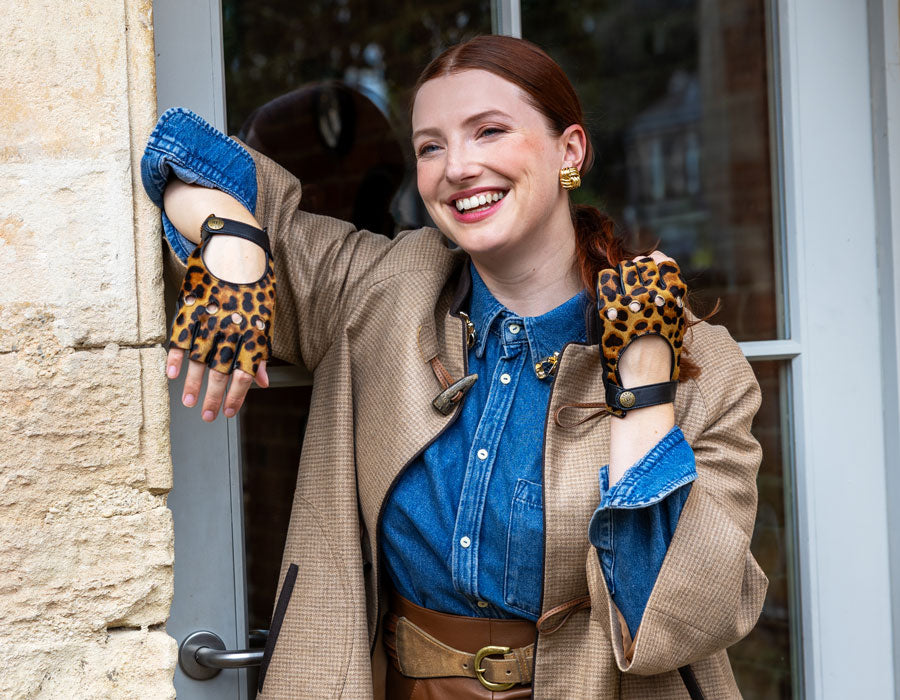 Woman wearing fingerless leather driving gloves in animal print