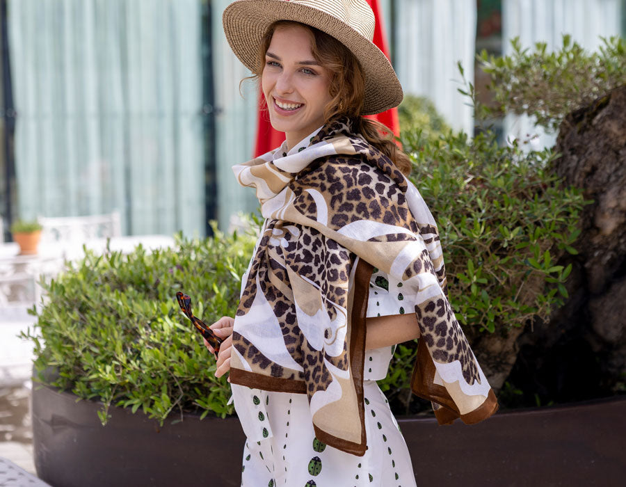 Woman wearing a brown animal print summer lightweight scarf outdoors