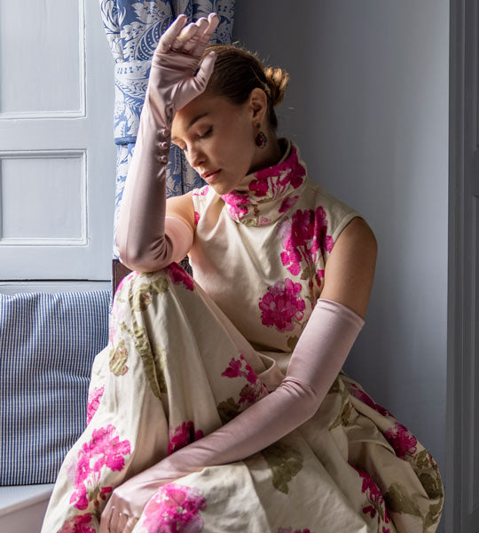 Woman wearing floral dress with long satin gloves in rose