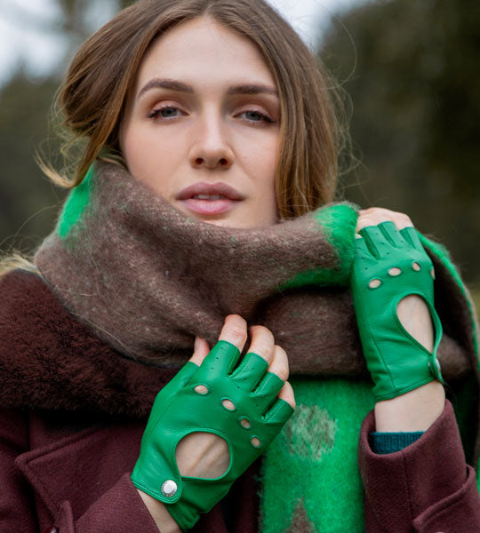 Woman wearing fingerless leather driving gloves in emerald 